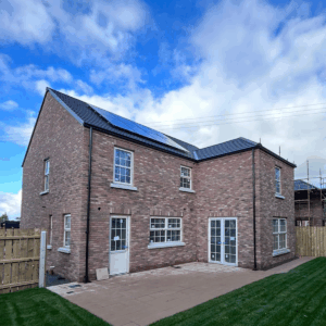 New build brick home with Encom solar panels installed on the roof under a bright sky